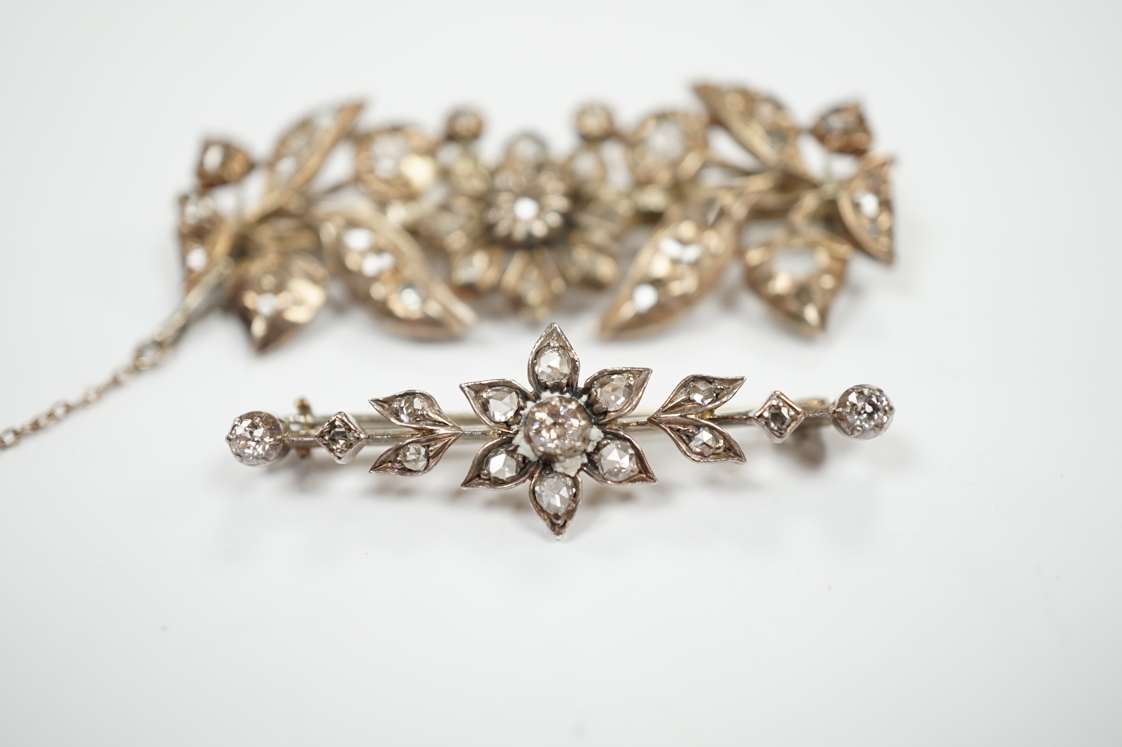 Two early 20th century yellow and white metal, rose cut diamond set foliate brooches, largest 51mm, gross weight 13.9 grams.